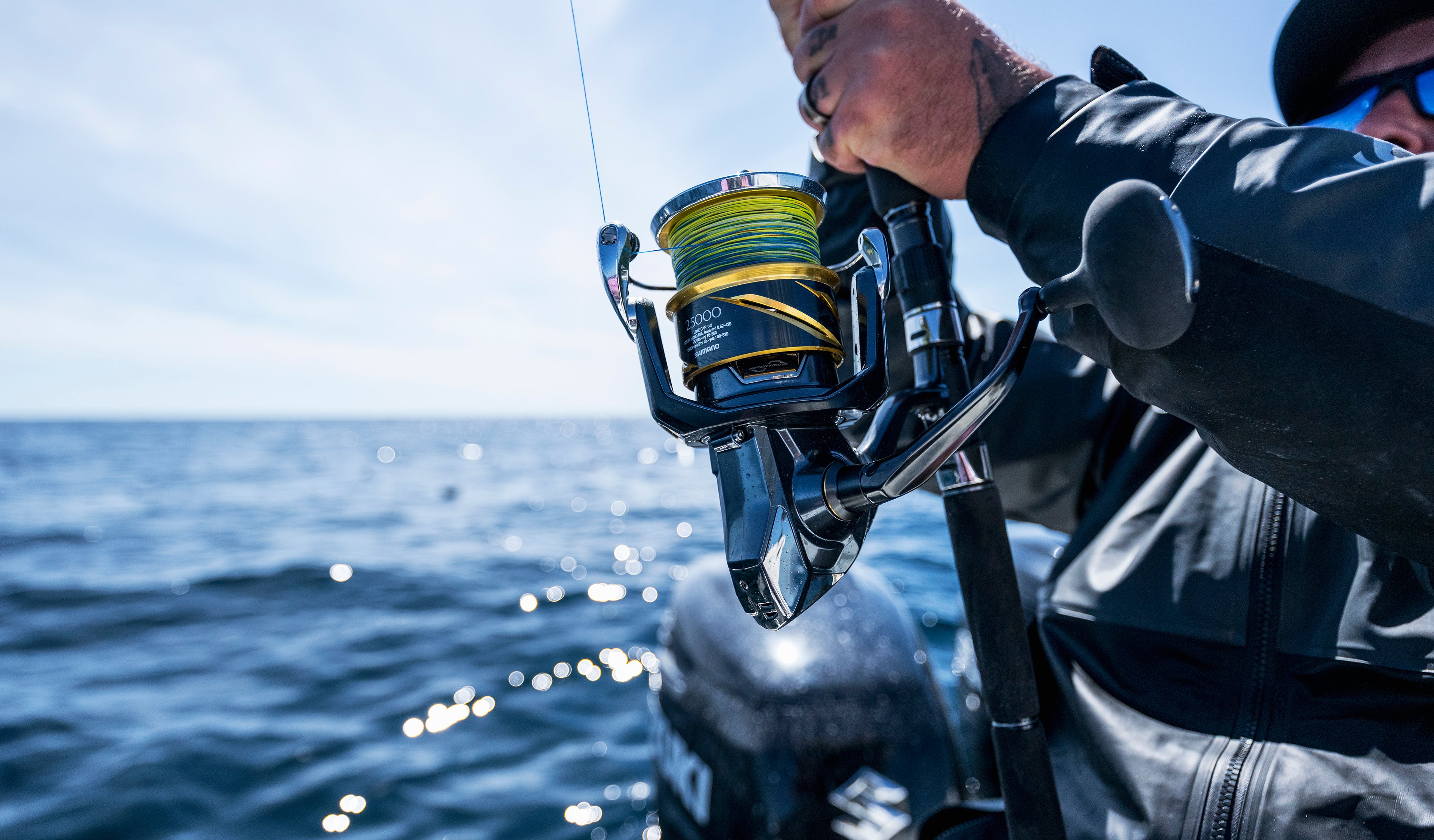 Angler using a spinning reel while saltwater fishing from a boat on open ocean